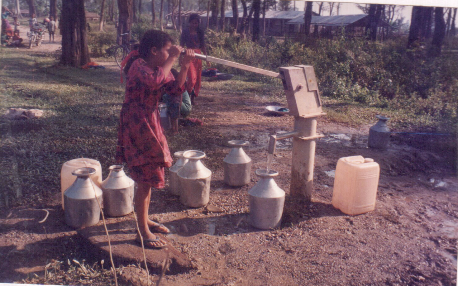 A community member collecting clean water from a hand pump